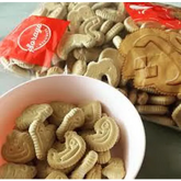 Bowl en zakken Arabische letterkoekjes met lichtgekleurde, glutenvrije vormkoekjes