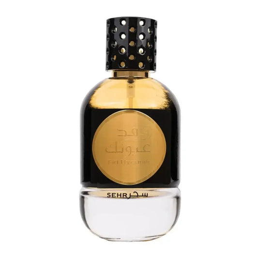 Een zwart glazen parfumflesje ard al zaafaran fid uyounik met een gouden label en geperforeerde gouden dop
