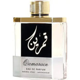 Een slanke doorzichtige glazen fles qamarain eau de parfum van ard al zaafaran met goudkleurige dop en metallic accenten