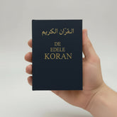 Blauwe boek met gouden letters van De Edele Koran in het Nederlands en Arabisch naast elkaar
