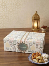 Een wit rechthoekig luxe eid cadeaupakket met een patroon van lantaarns, manen en sterren in zachte pastelkleuren en een eid mubarak label