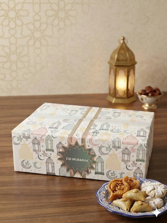 Een wit rechthoekig luxe eid cadeaupakket met een patroon van lantaarns, manen en sterren in zachte pastelkleuren en een eid mubarak label