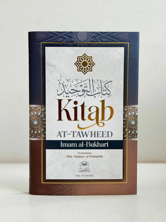 Een marineblauw en bruin hardbackboek met goudembossing arabisch schrift getiteld kitab at-tawheed door imam al-bukhari