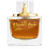 Een helder glazen parfumbottle met goudkleurige verstuiver met amberkleurige eau de parfum lattafa parfum sheikh shuyukh khusoosi