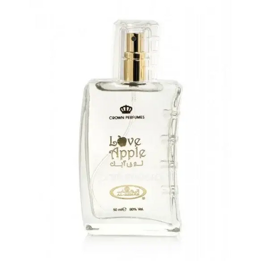 Clear glass bottle of crown perfumes love apple fragrance with a gold-tone spray nozzle and embossed arabic script on the label