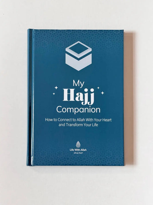 Blauw hardcoverboek my hajj companion met witte tekst en geometrisch logo op de kaft voor hajj begeleiding