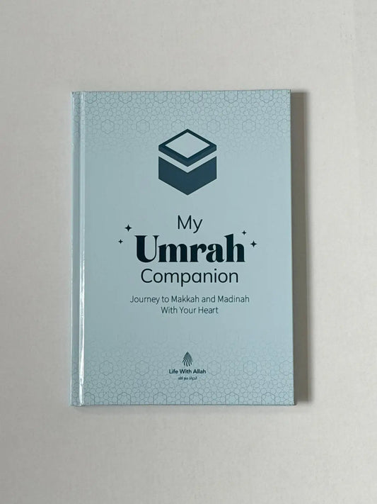 Lichtblauw hardbackboek my umrah companion met donkergroene geometrische ontwerp en subtiele rand voor umrah begeleiding