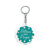 Teal sleutelhanger met witte bloemen en tekst Patience and Prayer in scriptletter