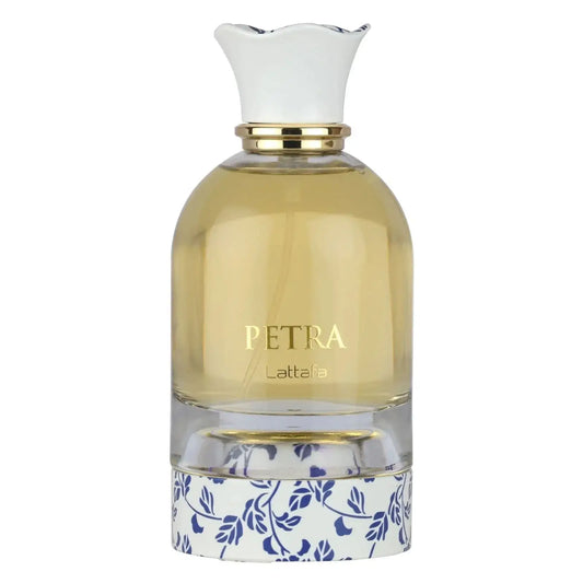Een heldere glazen parfumfles petra lattafa met een witte geperste dop, gouden accenten en blauwe bloemenprint