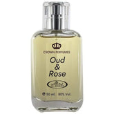Een heldere glazen fles al-rehab parfum oud en rose met zilveren spray en lichtgele vloeistof