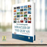 Blauwe hardcover Unchallengeable Miracles of the Quran met witte en gouden tekst en kleine afbeeldingen op de omslag