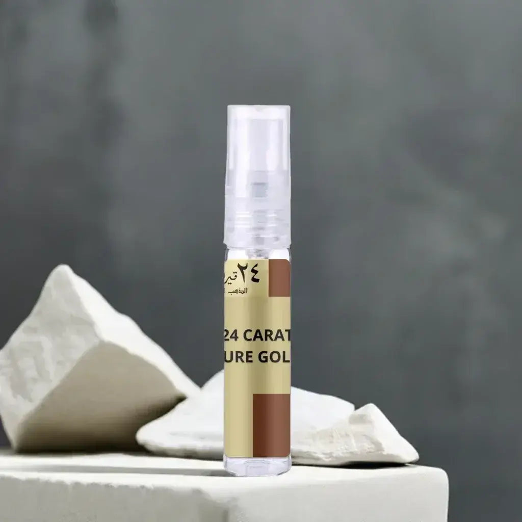 Een slanke, doorzichtige spuitfles met een gouden en bruine label met de tekst 24 carat pure gold staat rechtop