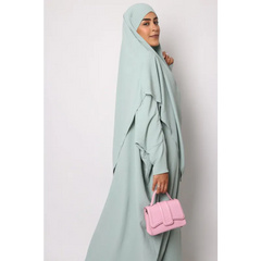 Mintgroene abaya met ronde hals, bijpassende hijab en roze handtas van aangenaam materiaal