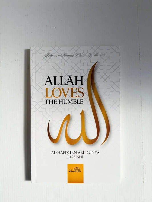 Witte hardcover boek met gouden folie letters en stijlvolle arabische kalligrafie getiteld allah loves the humble door al-hafiz ibn abi dunya