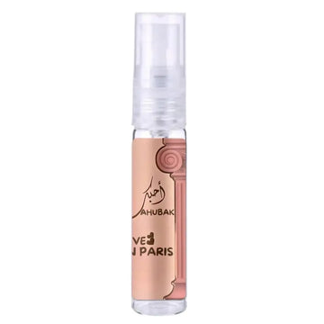 Een heldere glazen sprayfles met een perzikkleurig etiket en gouden details van ard al zaafaran ahubbak love in paris geur ve j paris