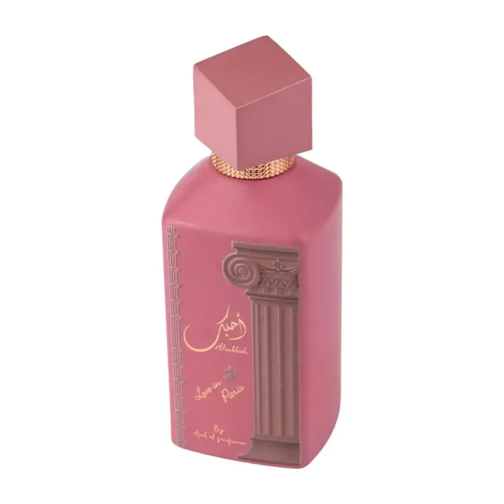Een roze rechthoekige Ard al Zaafaran Ahubbak Love in Paris parfumfles met een gouden klassieke zuil reliëf