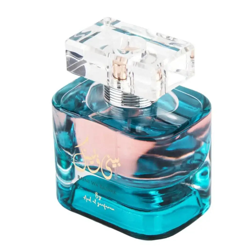 Een strak, turquoise glazen parfumfles met een geslepen kristallen dop en gouden letters van ard al zaafaran baini wa bainak
