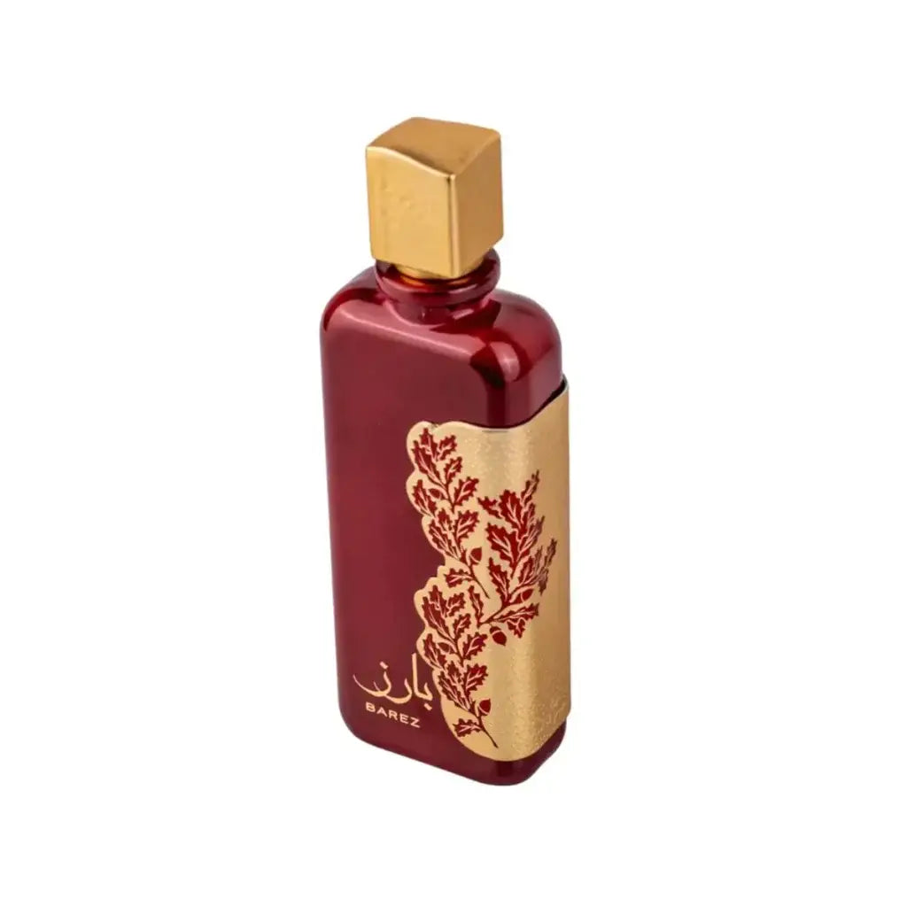 Een slanke rechthoekige rode parfumenfles met een gouden dop en een sierlijk gouden etiket met bladpatroon van ard al zaafaran barez