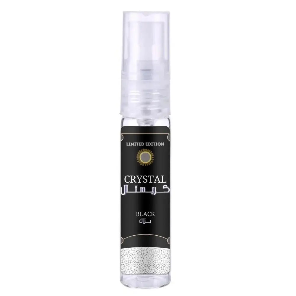 A sleek transparent spray bottle of ard al zaafaran crystal black with a black label and gold accents in english and arabic