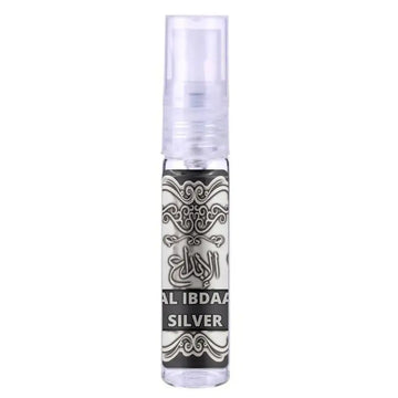Een helder glazen sprayfles met een zwarte en zilveren arabisch geëtiketteerd label al ibdaar silver, met aromatische vloeistof