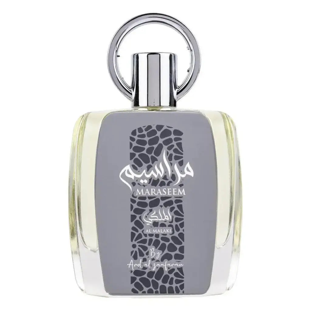 Een slanke transparante glazen fles maraseem parfum van al malaki met zilveren dop en arabische tekst op grijs label