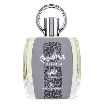 Een slanke transparante glazen fles maraseem parfum van al malaki met zilveren dop en arabische tekst op grijs label