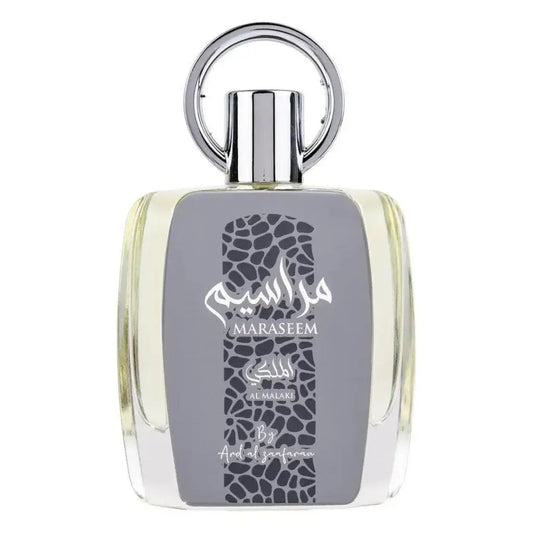 Een slanke transparante glazen fles maraseem parfum van al malaki met zilveren dop en arabische tekst op grijs label