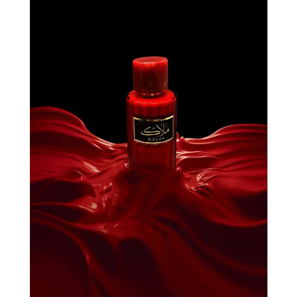 Een levendige rode glazen fles van malak parfum met zwarte label en gouden letters van ard al zaafaran milky malak