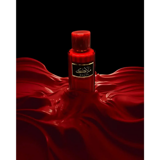 Een levendige rode glazen fles van malak parfum met zwarte label en gouden letters van ard al zaafaran milky malak