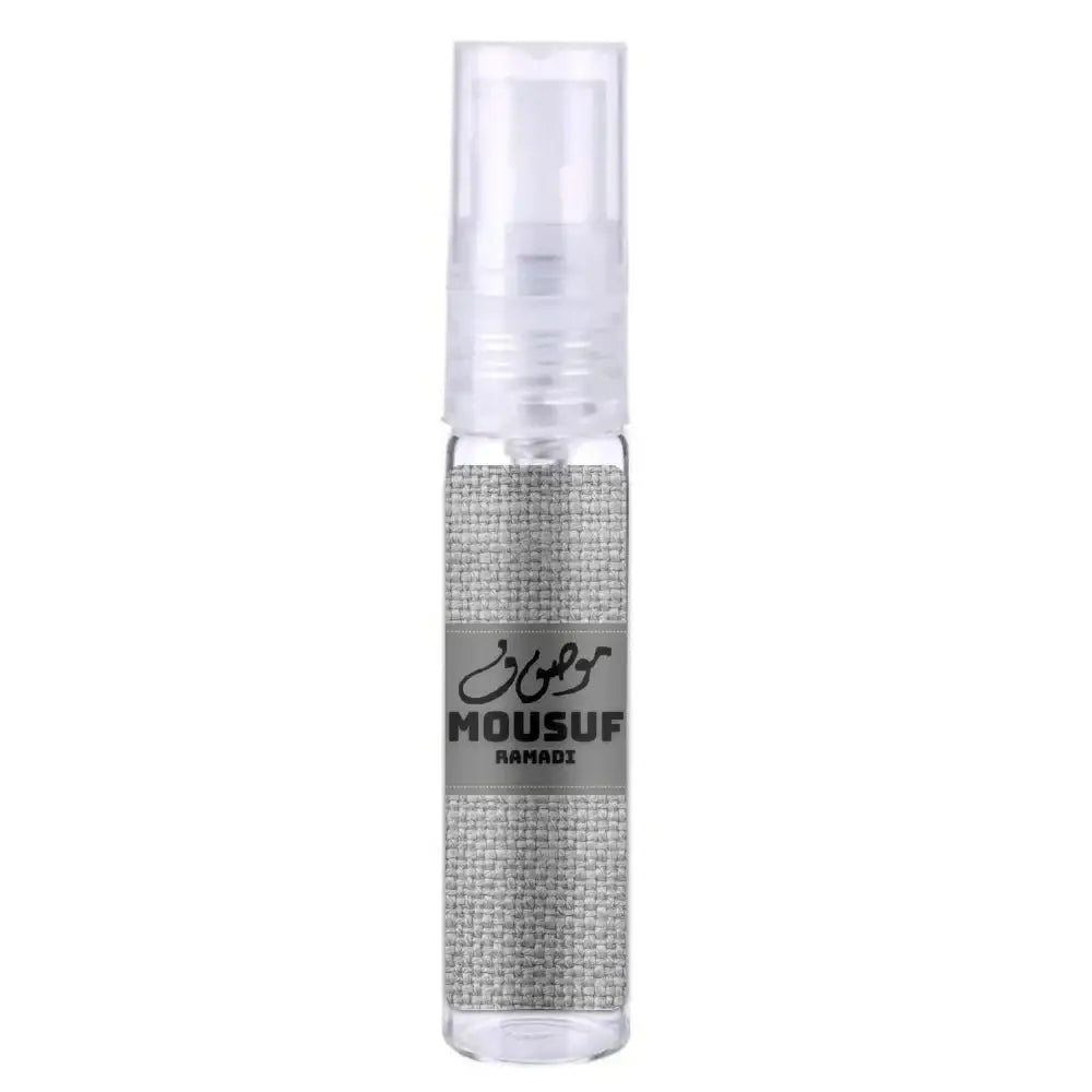 Een heldere glazen sprayfles met een zilverkleurige stoffen wrap en een grijs etiket van mousuf ramadi