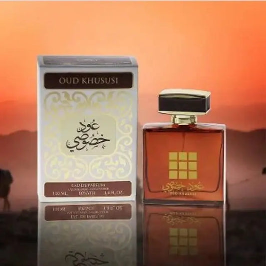 Een rechthoekige amberkleurige glazen parfumfles ard al zaafaran oud khususi met een zwart gouden dop en reliëf gouden rasterdesign
