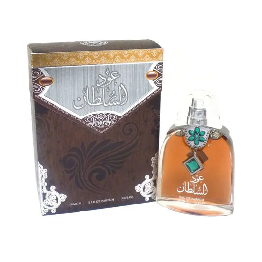 Een helder glazen parfumfles met zilveren spray en groene edelsteenhanger met amberkleurige eau de parfum labeled عجز لشاطان van ard al zaafaran oud al sultan