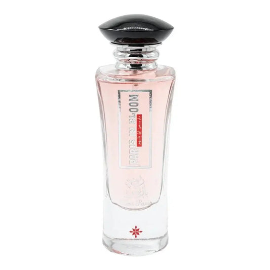 Een helder glazen parfumfles met zwarte dop en roze vloeistof van ard al zaafaran rose paris bloom met label paris in bloom