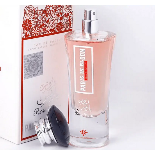 Een helder glazen fles ard al zaafaran rose paris bloom parfum met zilveren verstuiver en roze vloeistof