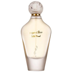Een slanke doorzichtige glazen parfumfles met een ronde gouden accenten dop en arabische tekst van ard al zaafaran silk mood