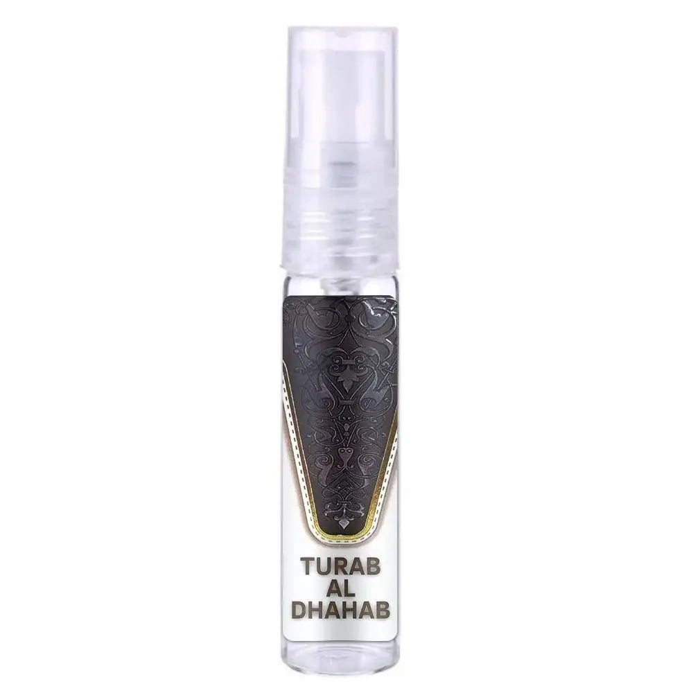 Een heldere glazen sprayfles met een zwart, sierlijk gegraveerd label met gouden rand en tekst turab al dhahab