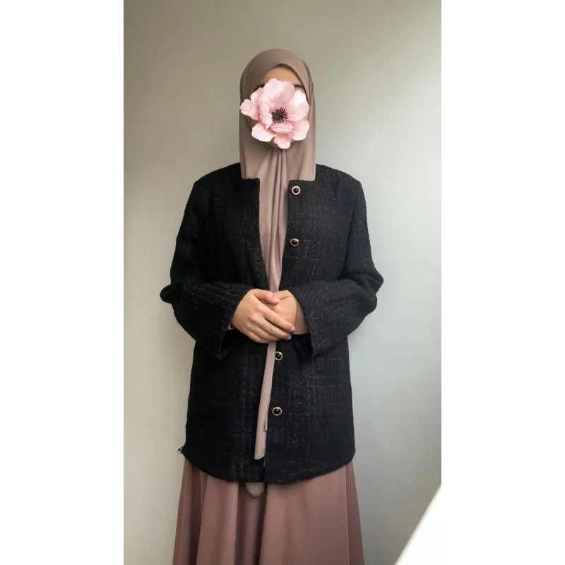 Zwarte boucléblijzer met beige sjaal en bloemmotief op gezicht