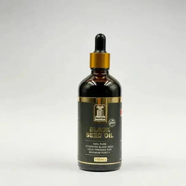 Donkere amberkleurige glazen fles met goudkleurige druppeldop en zwart label met gouden letters, ganoslam black seed olie koudgeperst 100ml