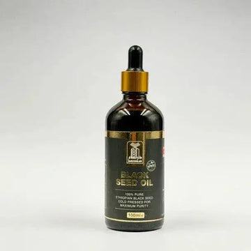 Donkere amberkleurige glazen fles met goudkleurige druppeldop en zwart label met gouden letters, ganoslam black seed olie koudgeperst 100ml