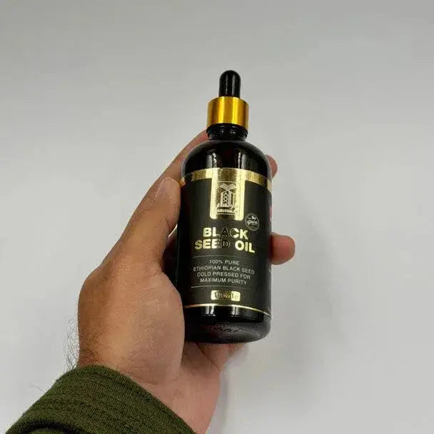 Ethiopische black seed olie koud geperst in een donkere glazen fles met gouden accenten en druppelaar 100 ml