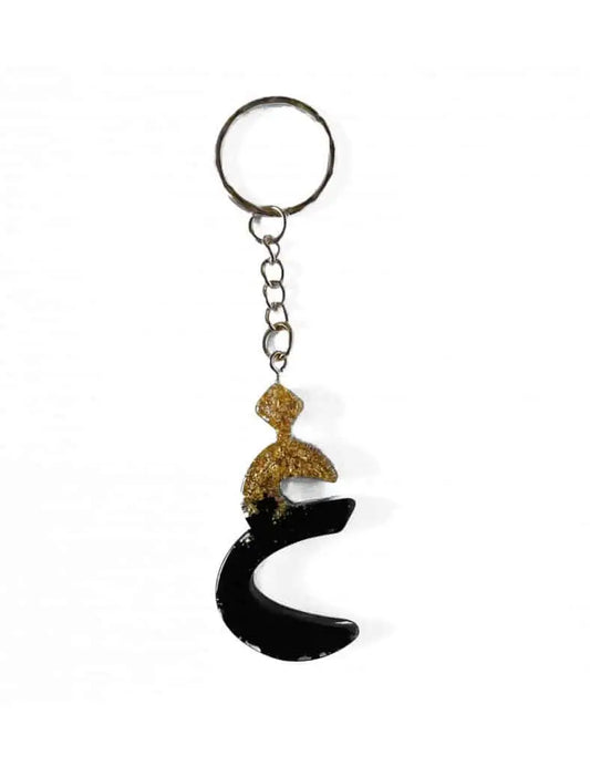 Ghayn arabisch alfabet sleutelhanger van zwarte en gouden resin met glittertop in vorm van letter qaf