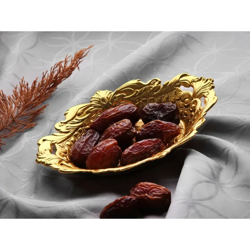 Gouden serveerschaal druppel met donkere rode dadels voor het serveren van dadels suikergoed en turks fruit