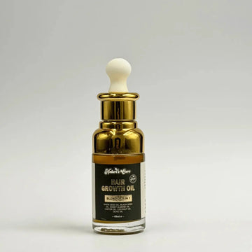 Een slanke transparante glazen fles haargroeiolie 30ml met gouden metalen dop en witte druppelaar van nature’s cure