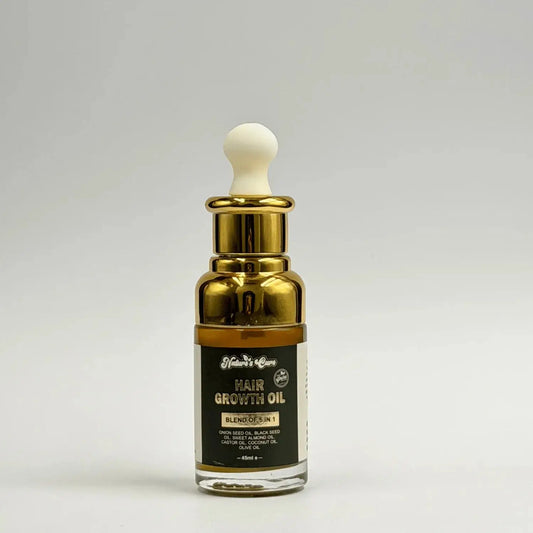 Een slanke transparante glazen fles haargroeiolie 30ml met gouden metalen dop en witte druppelaar van nature’s cure