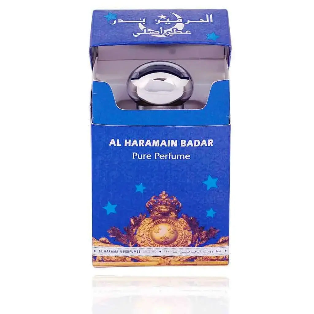 Een slanke zilverkleurige parfumfles met een ronde dop in een blauw doosje met gouden sterren van al haramain parfumolie badar
