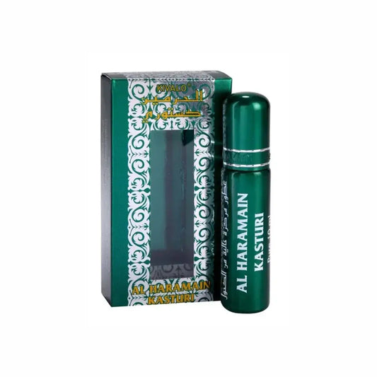 Groene metalen rollerball parfumfles met zilveren band en witte letters naast sierlijke groene en zilveren verpakking al haramain parfumolie kasturi