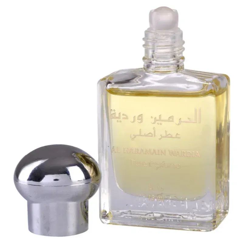 Een helder glazen flesje met zilveren dop gevuld met goudgeel al haramain parfumolie wadia met arabische tekst