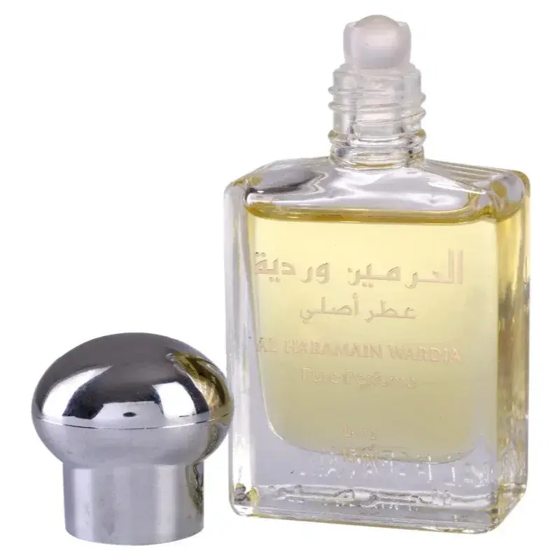 Een helder glazen flesje met zilveren dop gevuld met goudgeel al haramain parfumolie wadia met arabische tekst