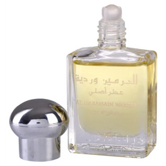 Een helder glazen flesje met zilveren dop gevuld met goudgeel al haramain parfumolie wadia met arabische tekst