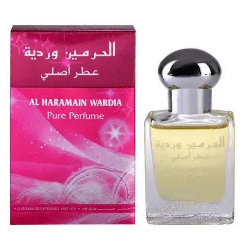 Een heldere glazen fles al haramain wardia pure parfumolie met zilveren dop en lichtgele vloeistof naast roze verpakking